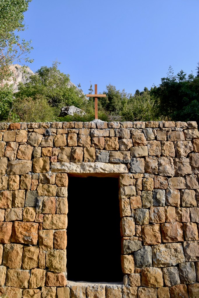small wooden cross over the entrance to a stone chapel